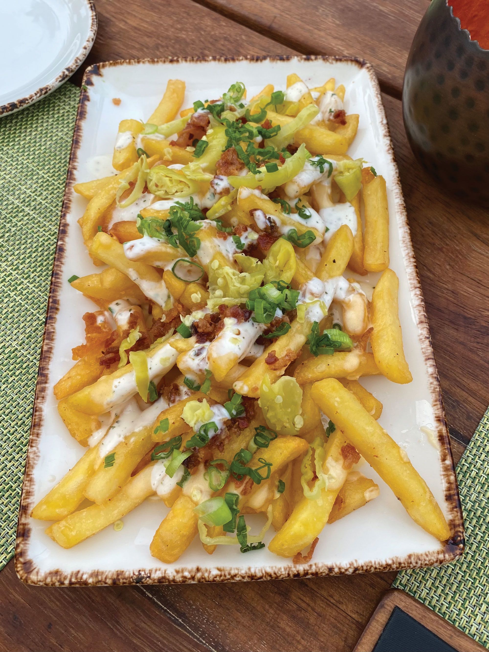 The Train Wreck Fries at the Rooftop Garden Grill on the Celebrity Edge, topped with bacon, scallions, four cheeses, hot peppers and ranch dressing. (TW photo by Johanna Jainchill)