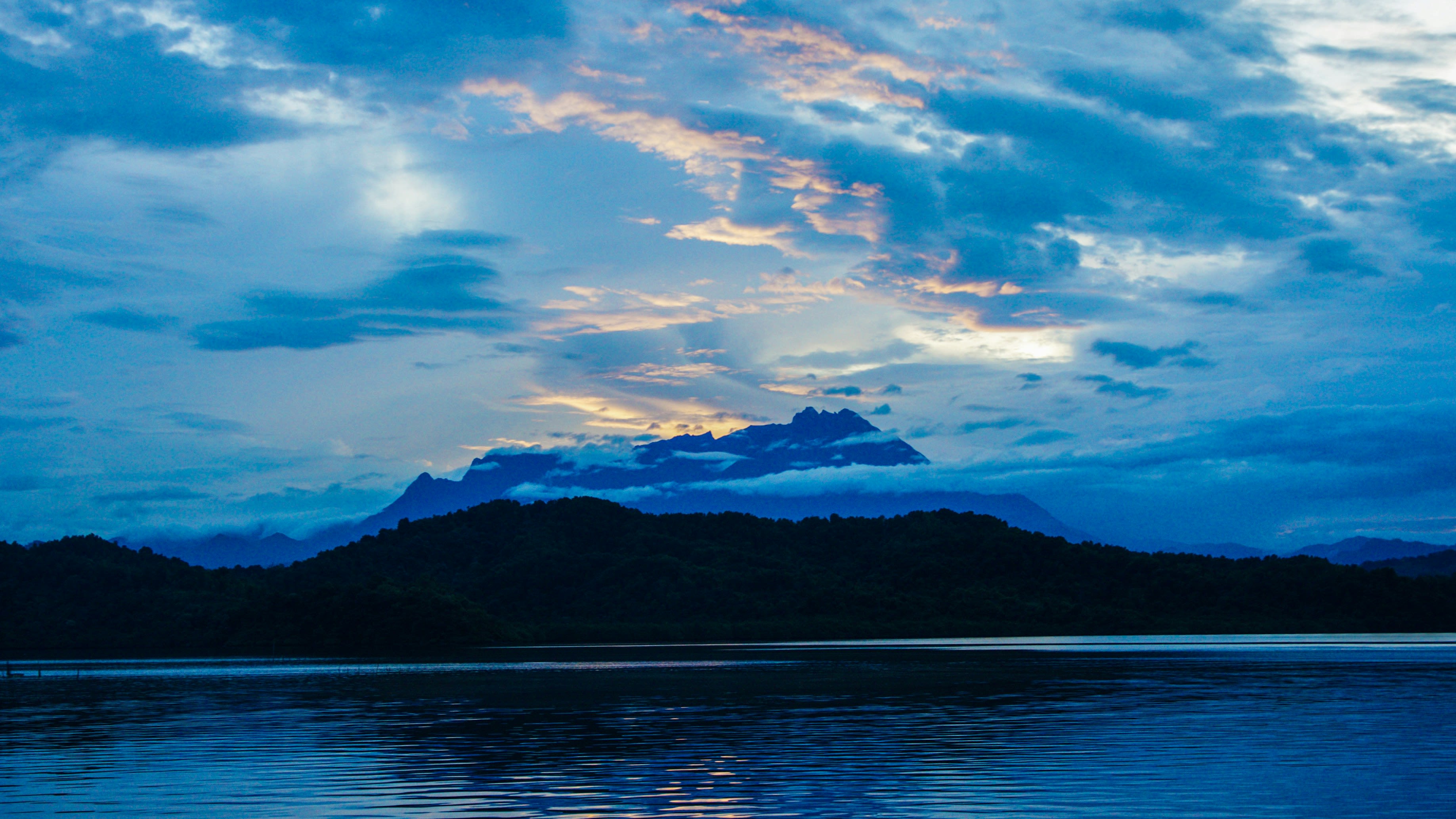 A blue sky with clouds reflecting in the water