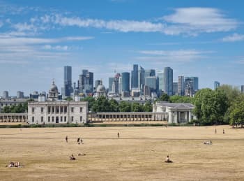 Scenic view of London's skyline from Greenwich Park on a sunny day.