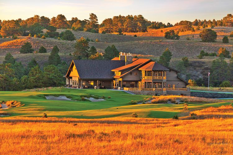 The lodge and 18th green at the Prairie Club Pines Course back up to central Nebraska’s towering sand dunes. (Photo Courtesy of The Prairie Club)