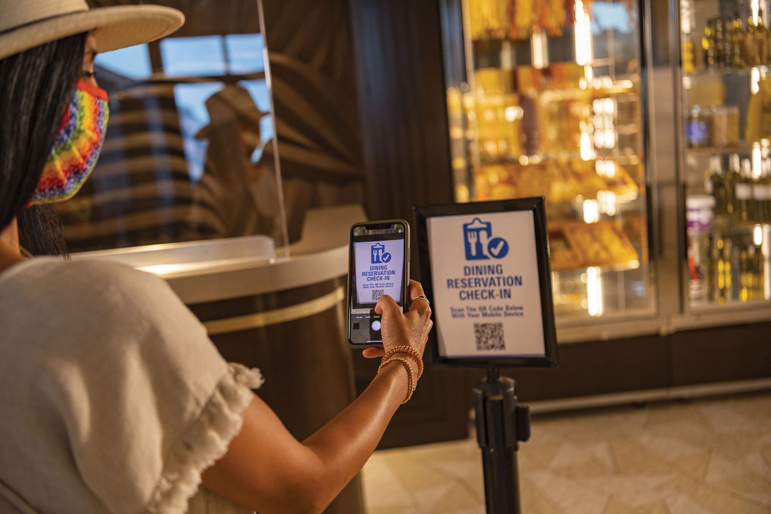 A Disney World guest using a cellphone to check in at a table-service restaurant.