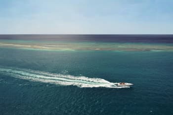 white speedboat running in middle of ocean during daytime