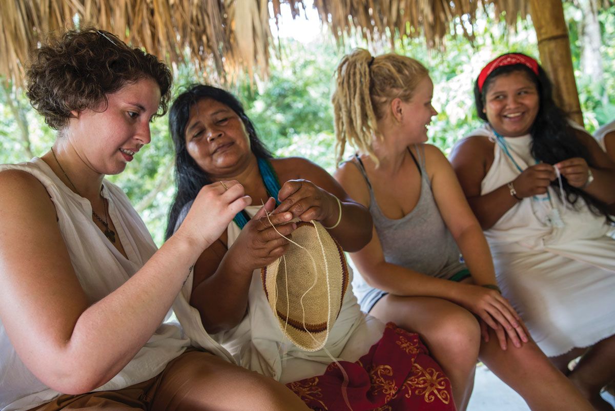 Guests on one of G Adventures’ Colombia Lost City trips visit with Wiwa women.