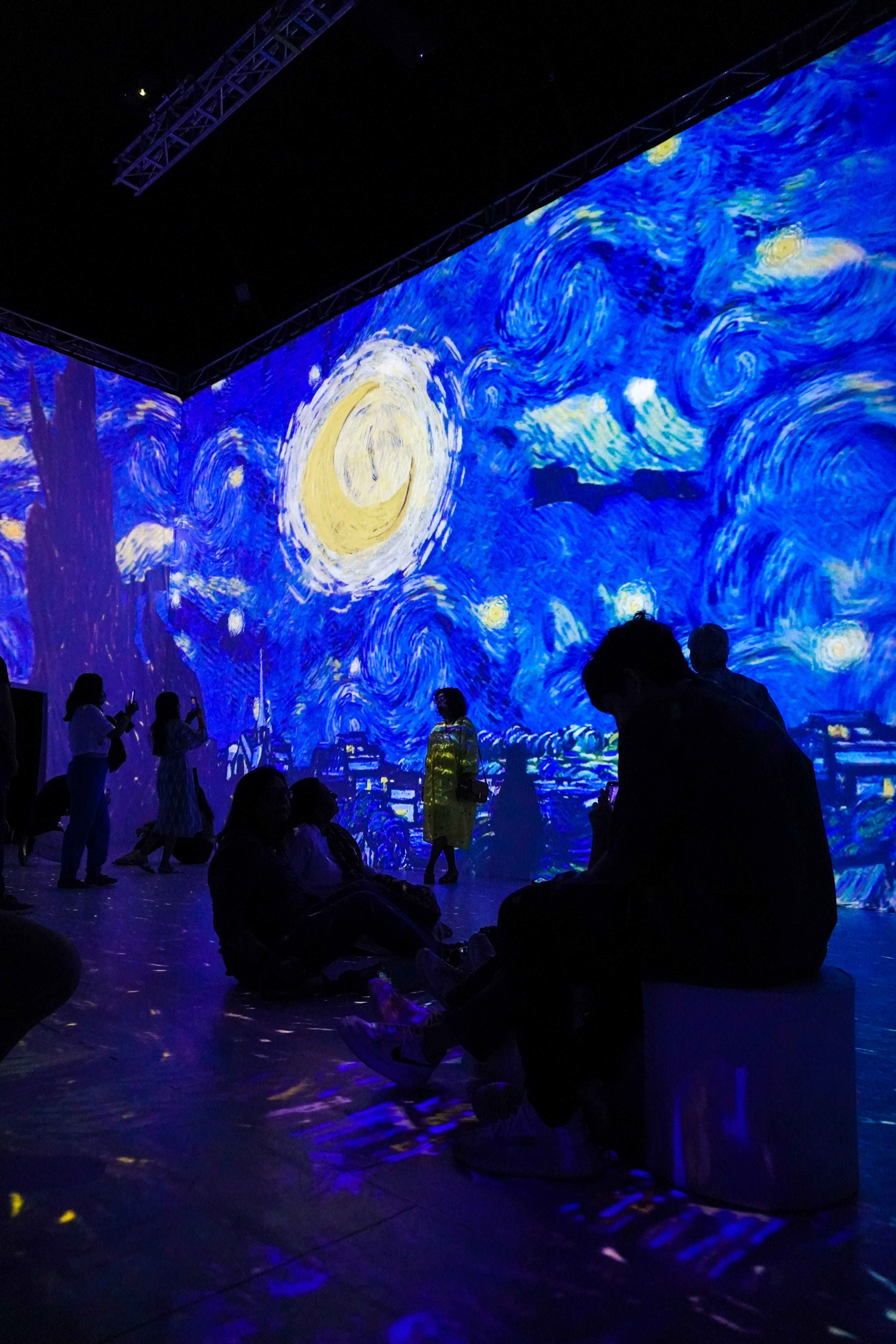 a group of people sitting in front of a painting