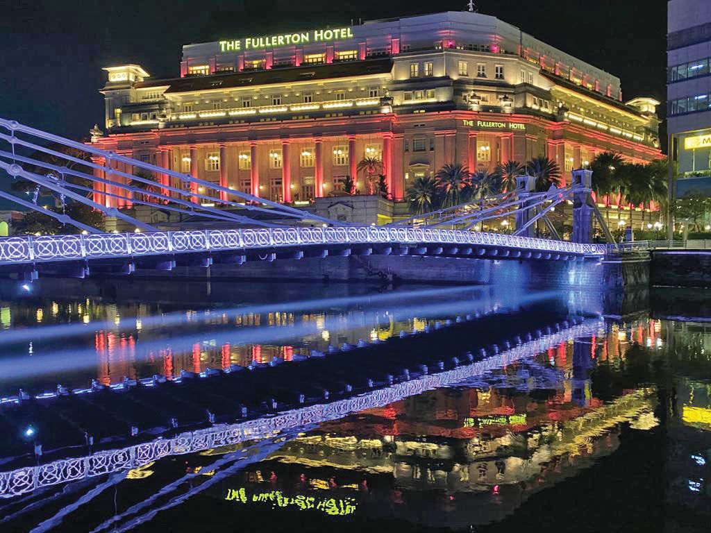 The Cavenagh Bridge illuminated at night above the Singapore River, with the Fullerton Hotel in the background. Thus far, the focus has been on domestic tourism in the city. (Photo by Yeoh Siew Hoon)