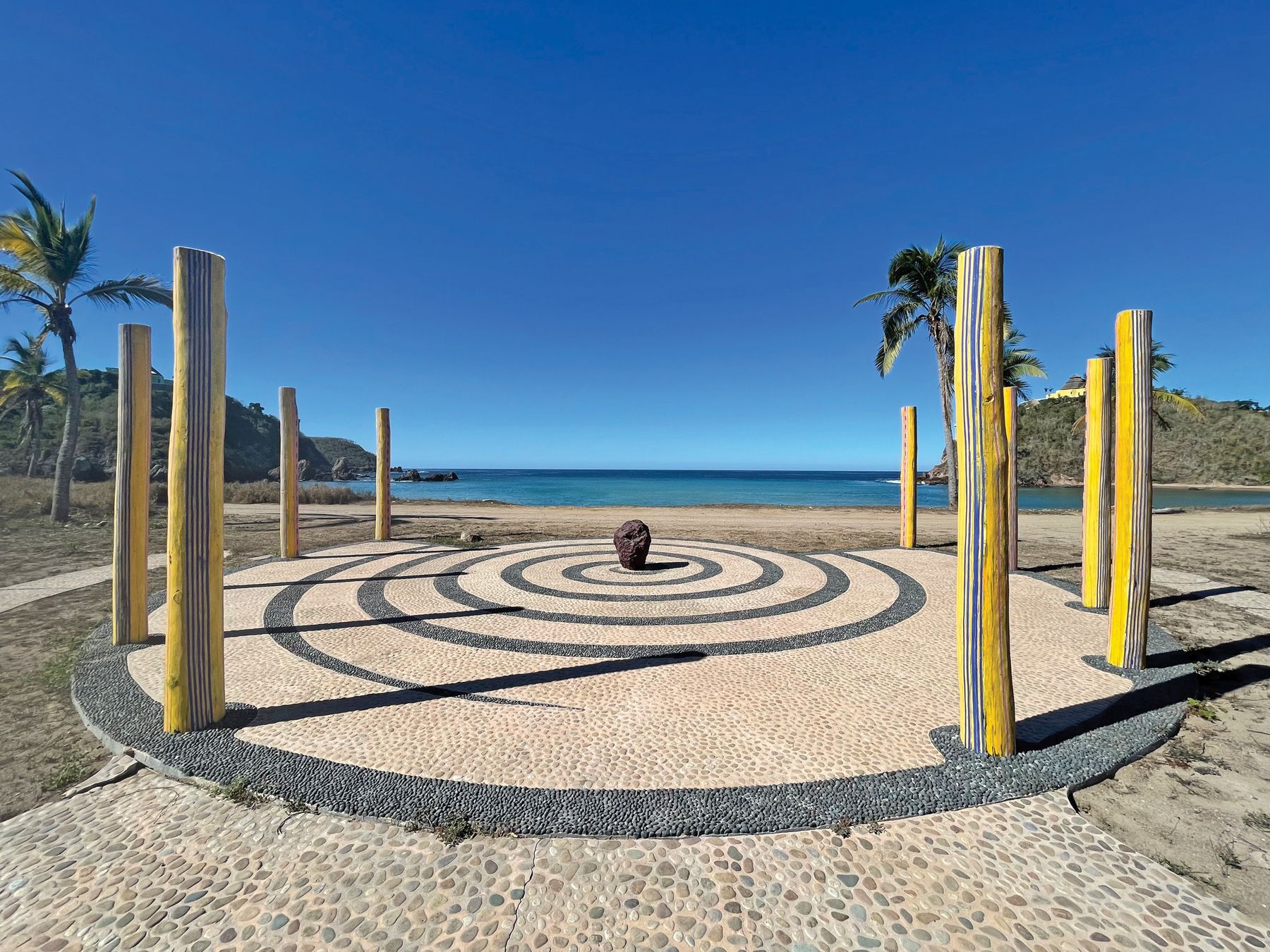 A meteor is the centerpiece of an installation on a quiet bay on the property. The Sol de Oriente is perched on the cliff on the right.