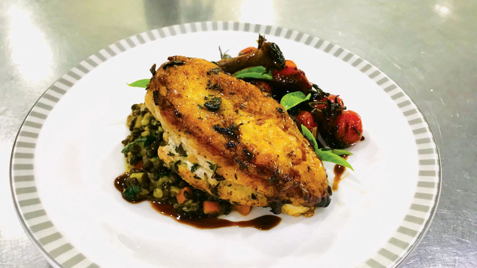Singapore Airlines’ herb-roasted chicken breast, braised black beluga lentils and roasted, caramelized tomatoes, cooked and plated by the carrier’s global food and beverage director Antony McNeil. (Photo by Antony McNeil)
