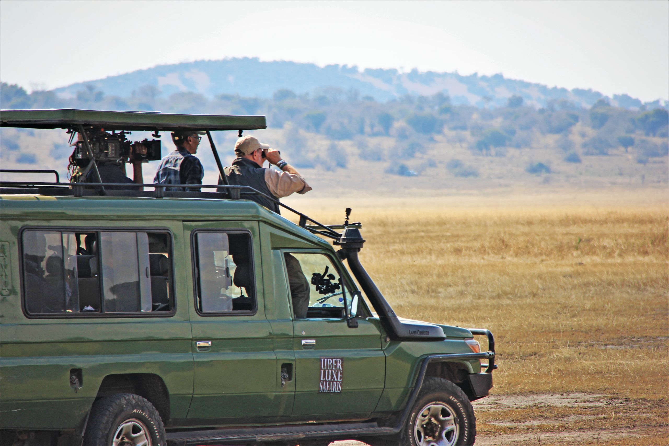 CBS News travel editor Peter Greenberg, with binoculars, and Rwandan president Paul Kagame on safari in Akagera National Park.