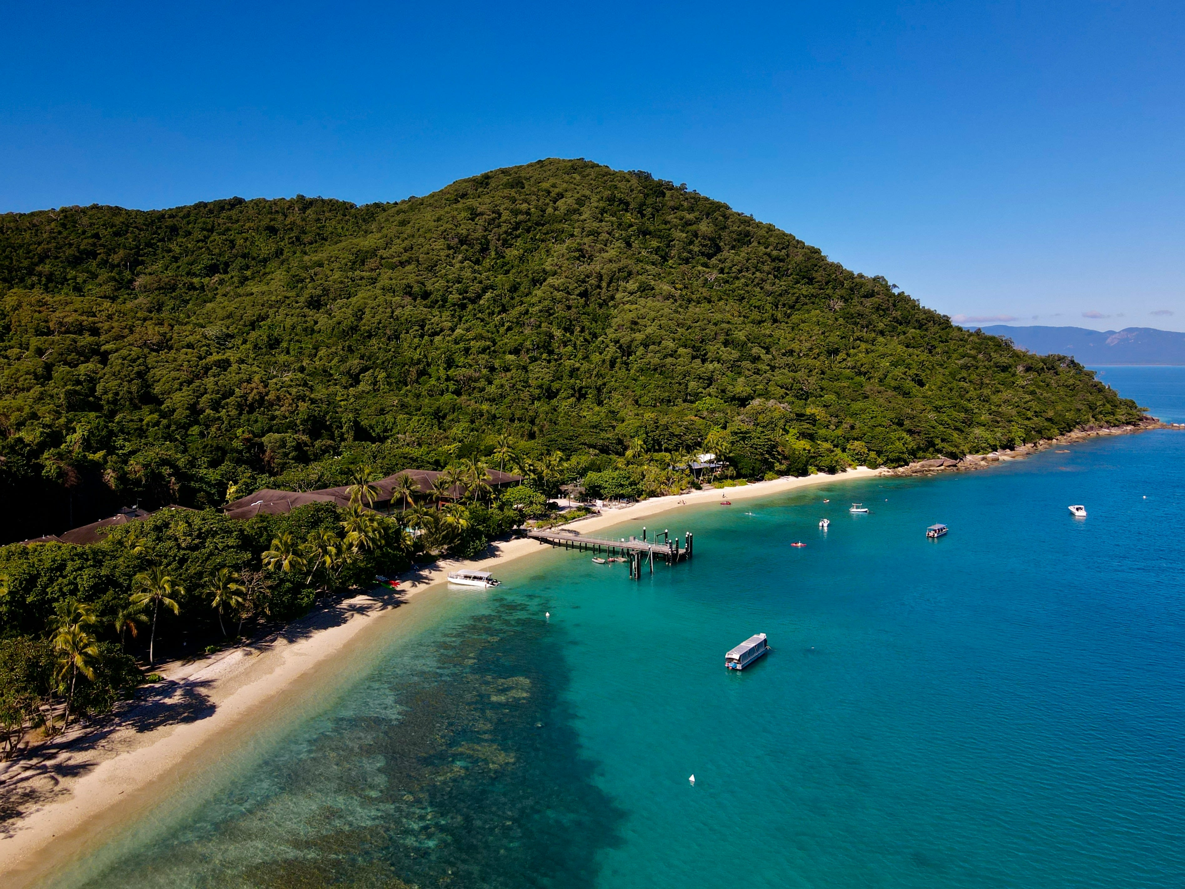 an aerial view of a tropical island with boats