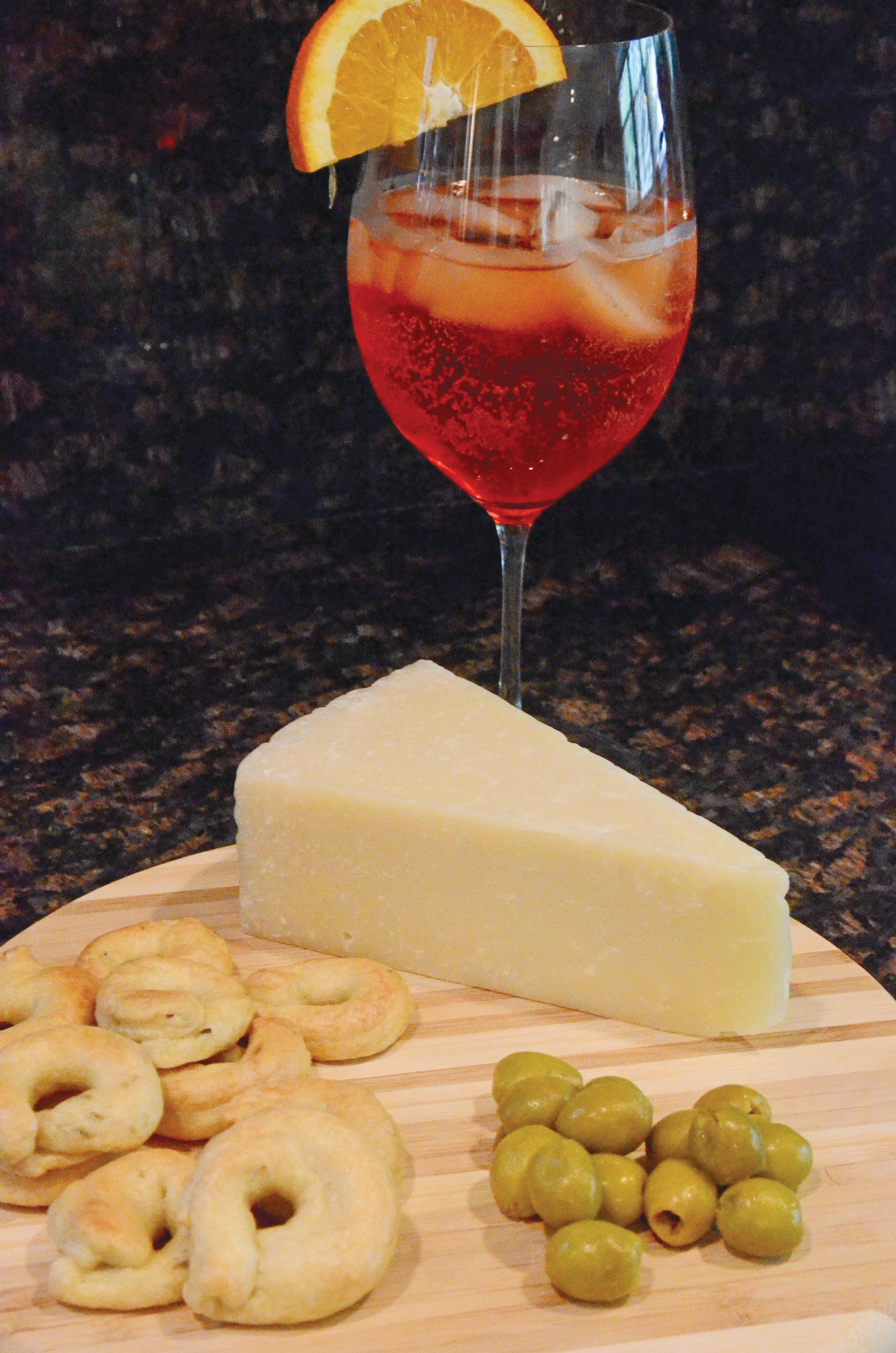 An Aperol Spritz with an accompanying cheese board featuring parmigiano reggiano, olives and taralli. (TW photo by Jamie Biesiada)