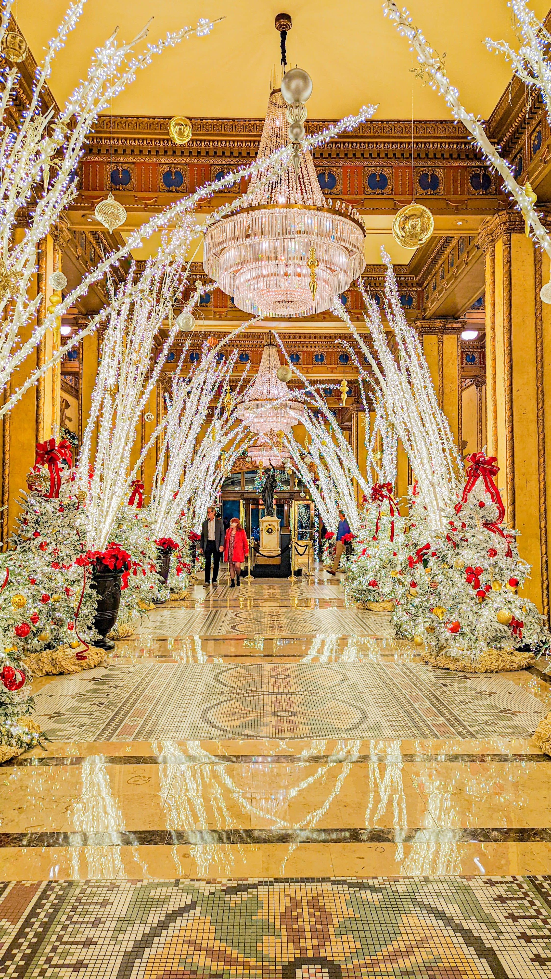 a large room with a chandelier and christmas decorations