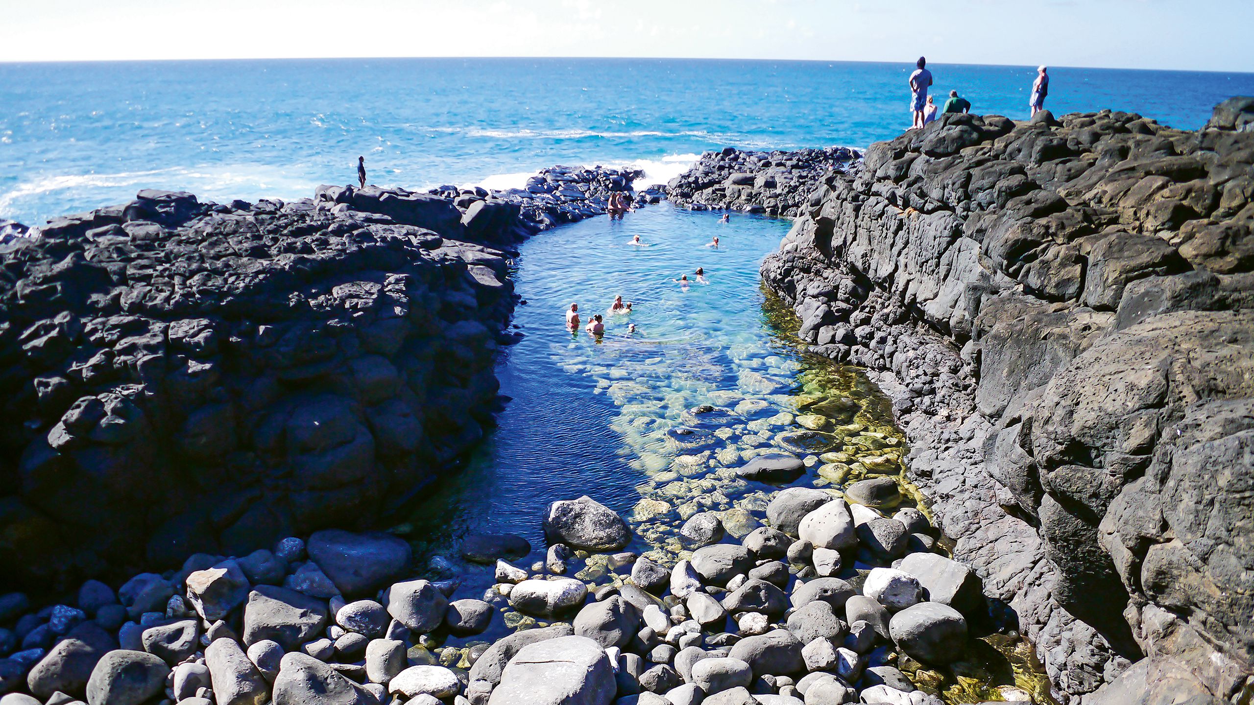The Queen’s Bath, a seaside pool on Kauai, is picturesque but perilous. Visitors still flock there despite it being on the Kauai Visitors Bureau’s do-not-promote list. Photo by HappySari/Shutterstock.com