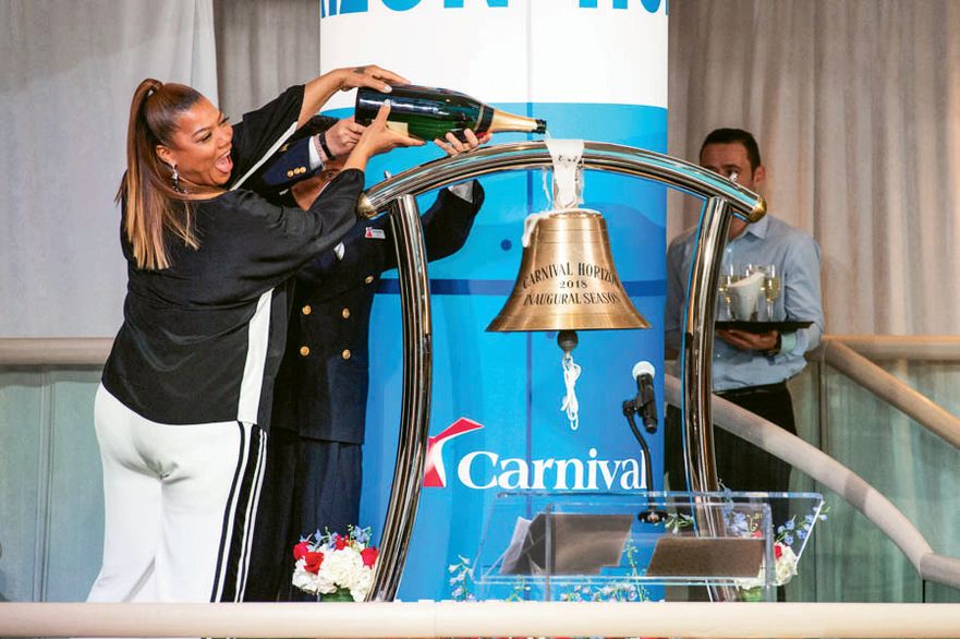 Entertainer and godmother Queen Latifah pours champagne on the ship's bell of the Carnival Horizon.