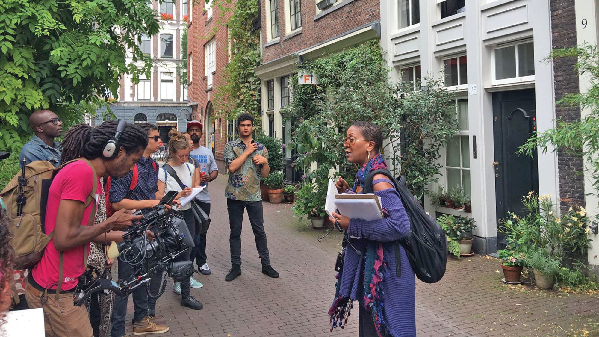 Jennifer Tosch, founder of Black Heritage Tours in Amsterdam, points out gable stones that depict the country’s deep ties to slavery. (Photo by Jennifer Tosch)