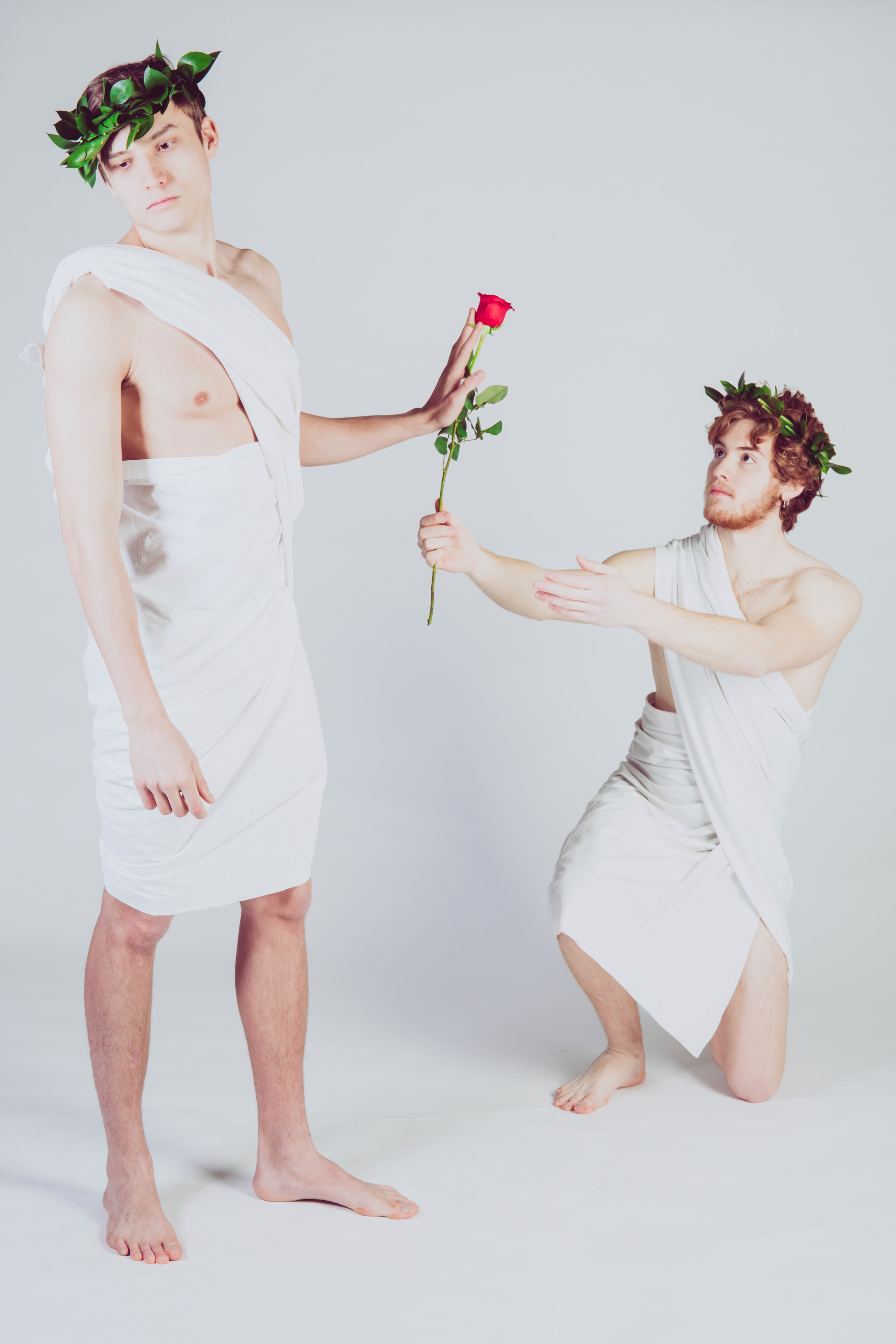 man giving rose to another man