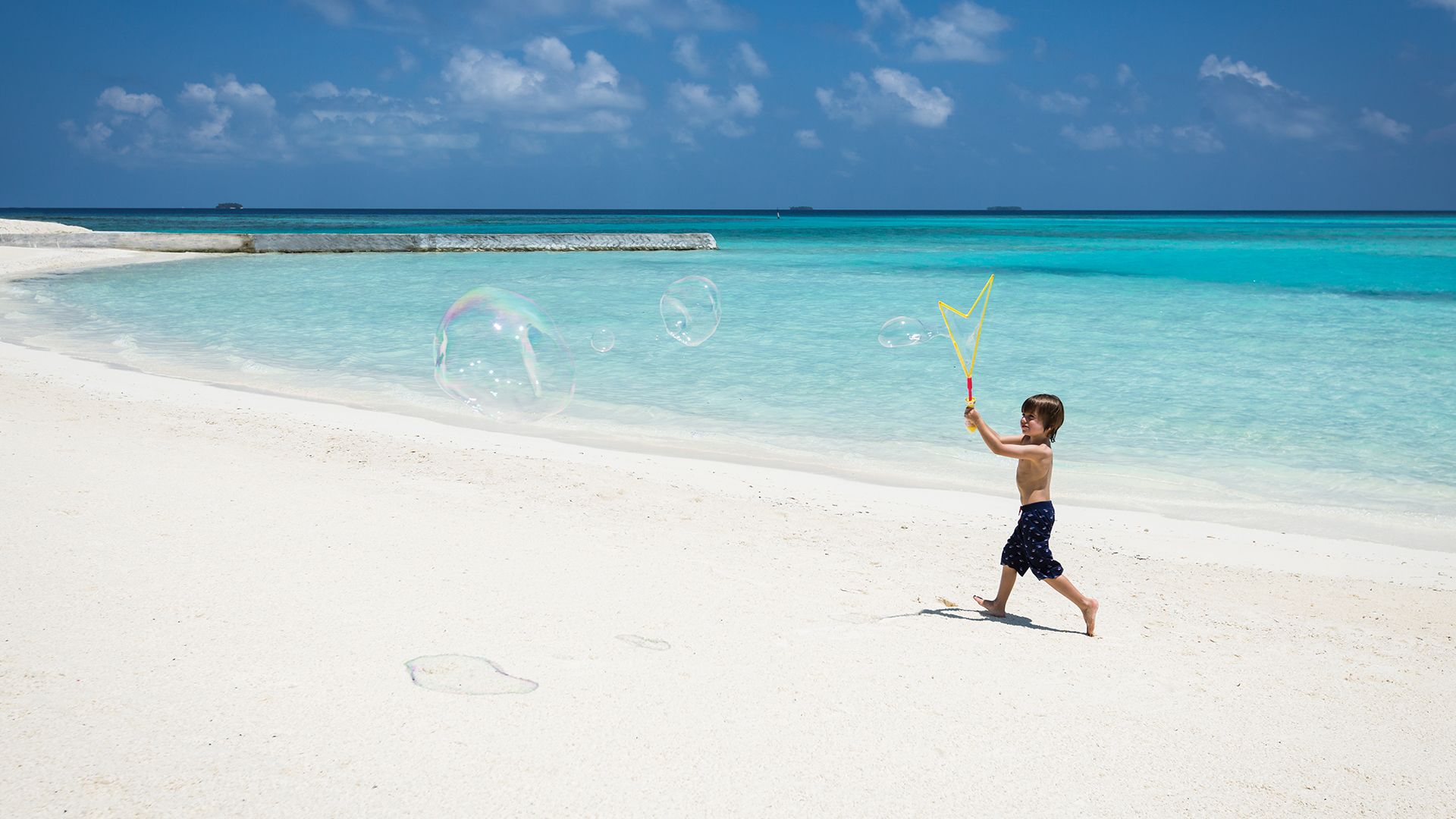A child plays on the beach at Anantara’s Niyama Private Island Maldives.