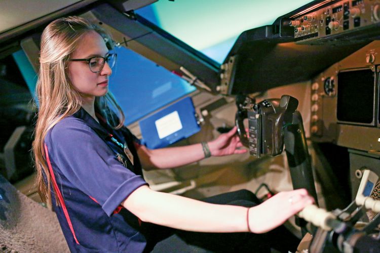 Madison Wolf, a senior aviation student at Metropolitan State University of Denver, operates a flight simulator at the United Airlines Flight Training Center in Denver in February. (Photo by Alyson McClaran for MSU Denver)