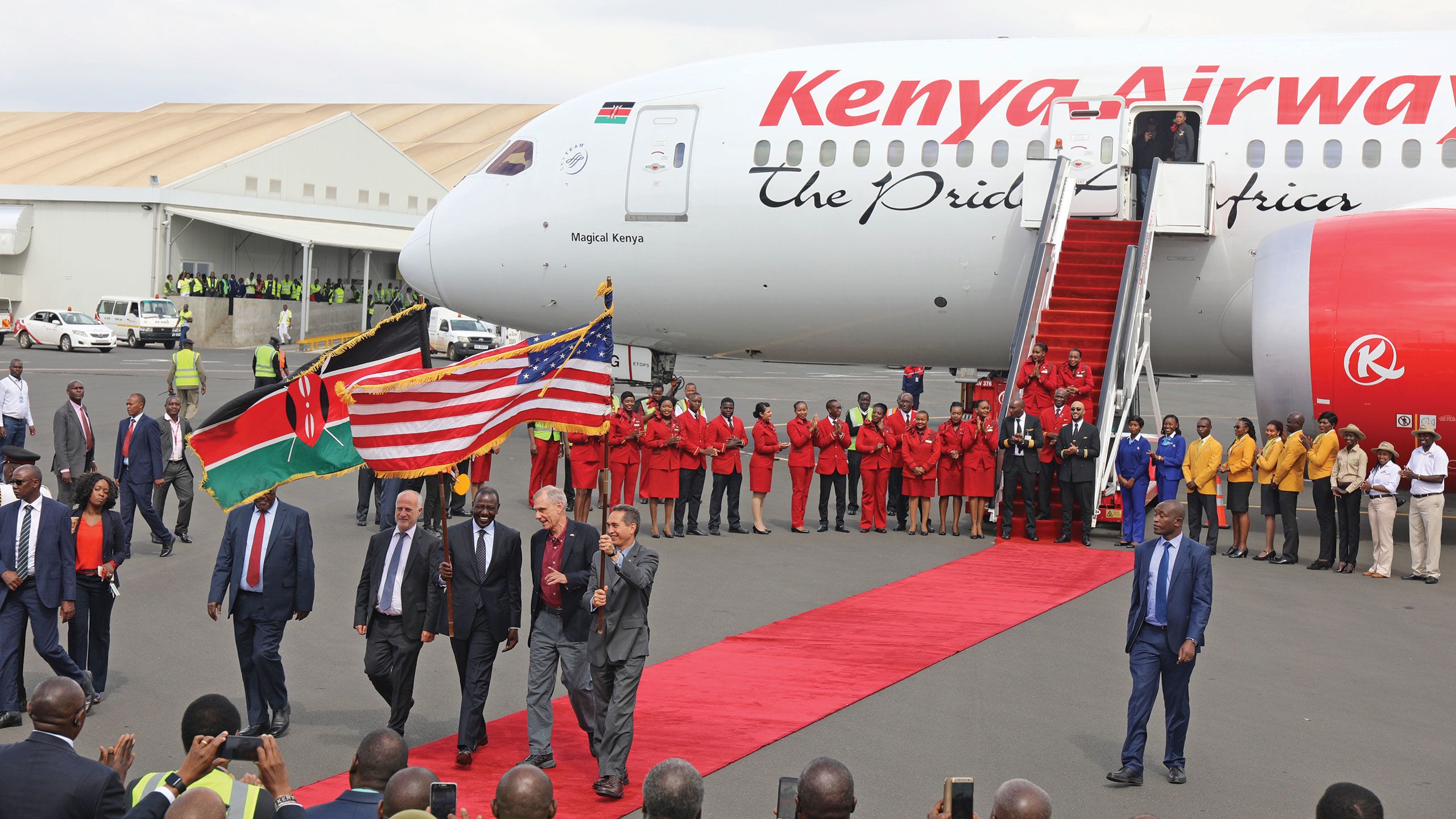 Kenya’s deputy president William Ruto, center, U.S. ambassador to Kenya Robert Godec, in a red shirt, and Kenya Airways chairman Michael Joseph, left of Ruto, help celebrate the first nonstop commercial flight between the U.S. and Kenya at Nairobi’s Jomo Kenyatta Airport in October. Photo courtesy of Kenya Tourism Board