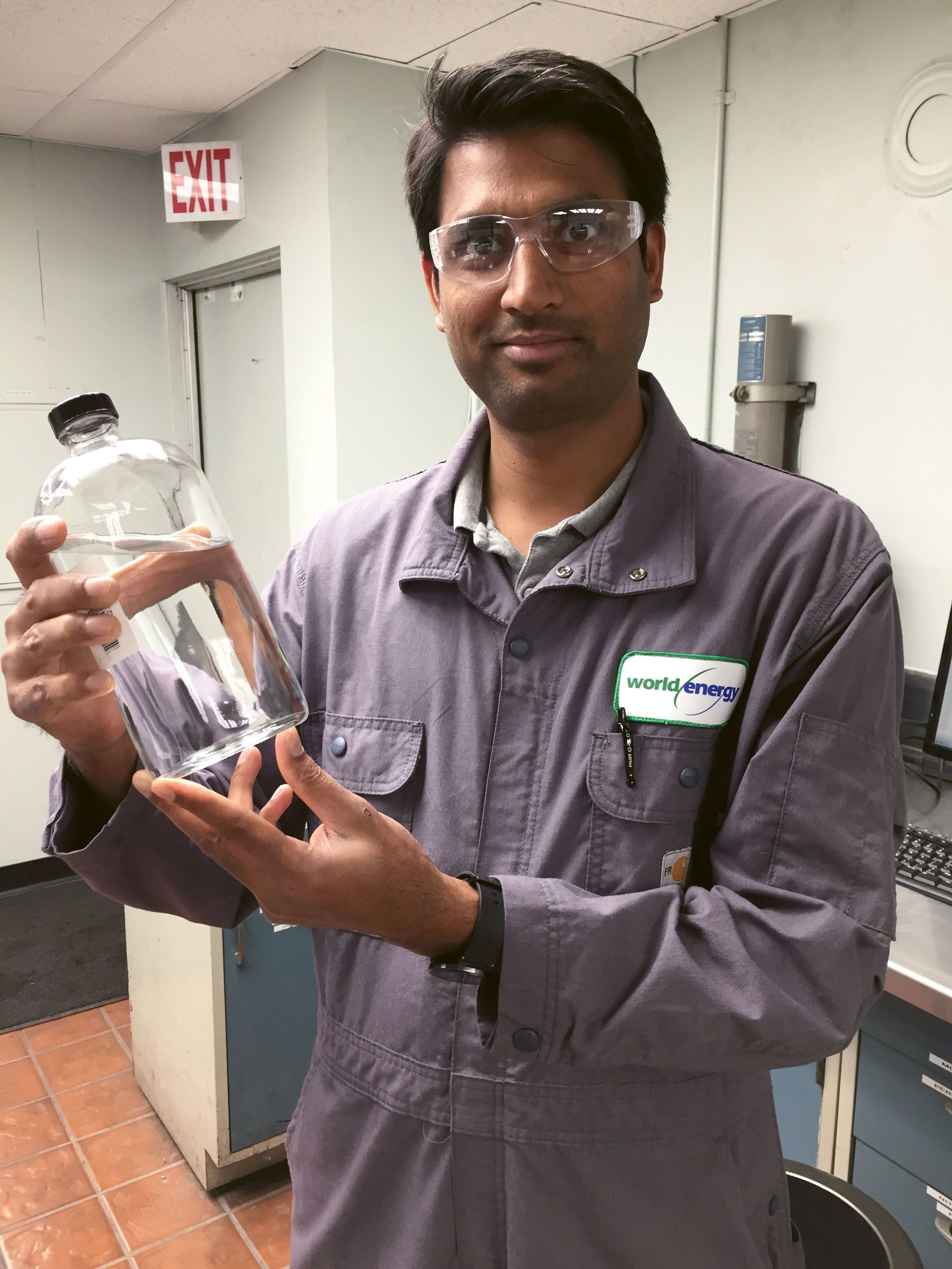 Vinay Panwar, lab manager at the World Energy refinery in Paramount, Calif., holds a bottle of the company’s jet fuel made from animal fats, vegetable oils and used cooking oils. (Courtesy of World Energy)