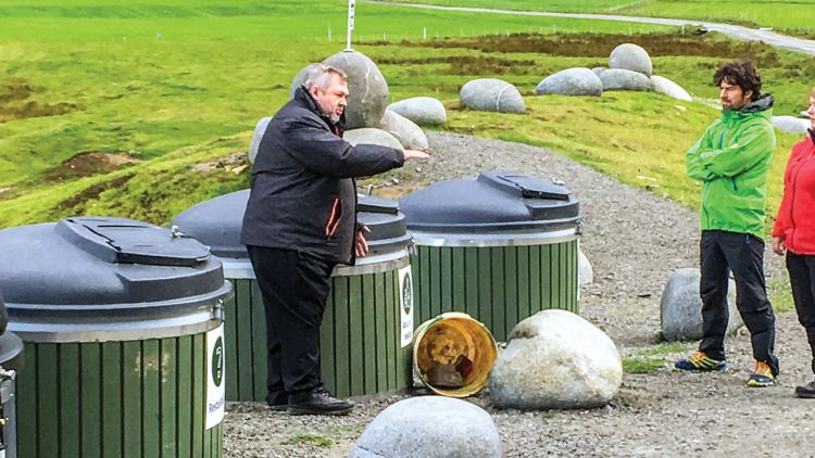Eldar Andersen with the new industrial-strength garbage cans the Uttakleiv village has installed to cope with the garbage tourists generate. Photo by William Nash