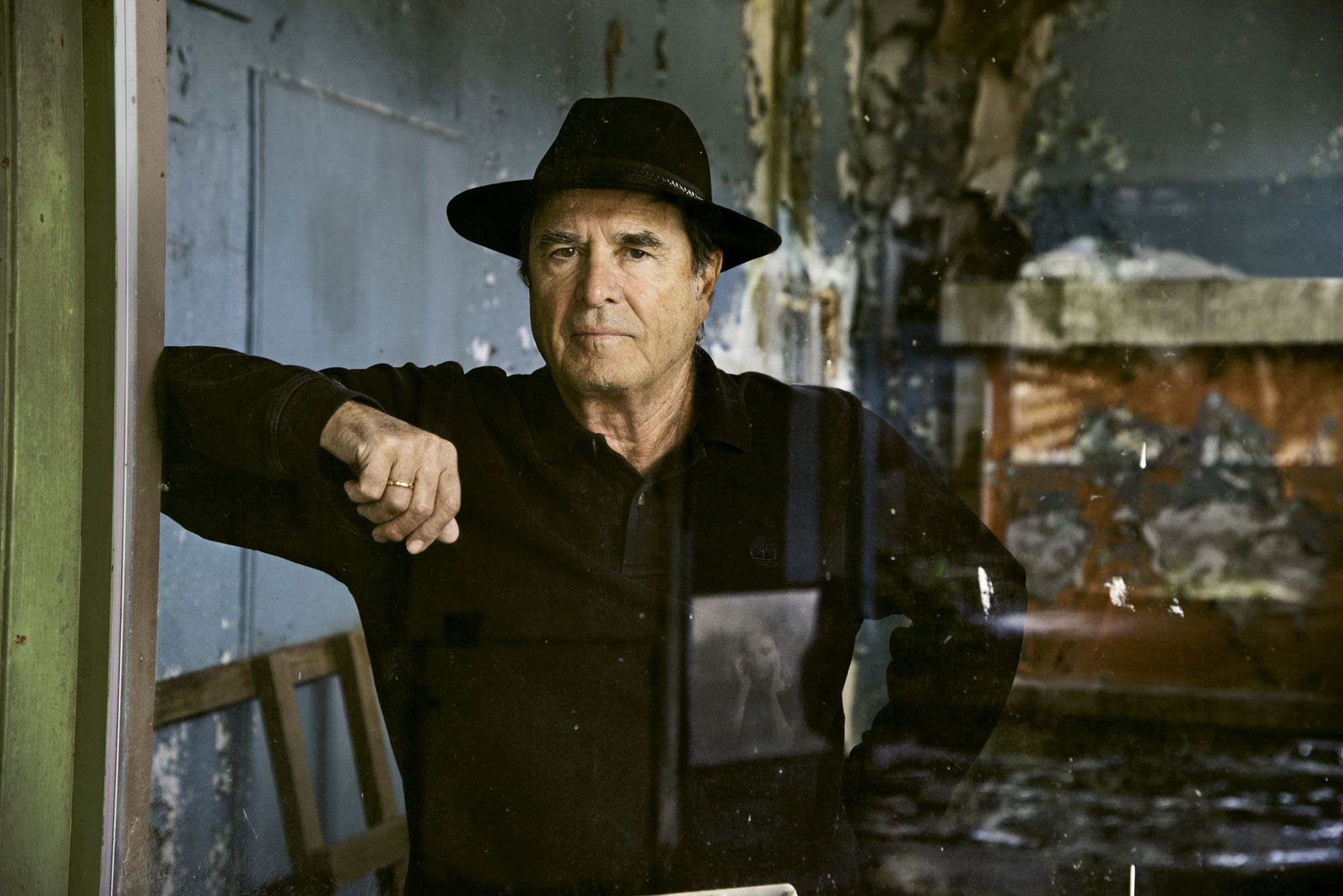 Paul Theroux leans against a doorway. (Photo by Steve McCurry)