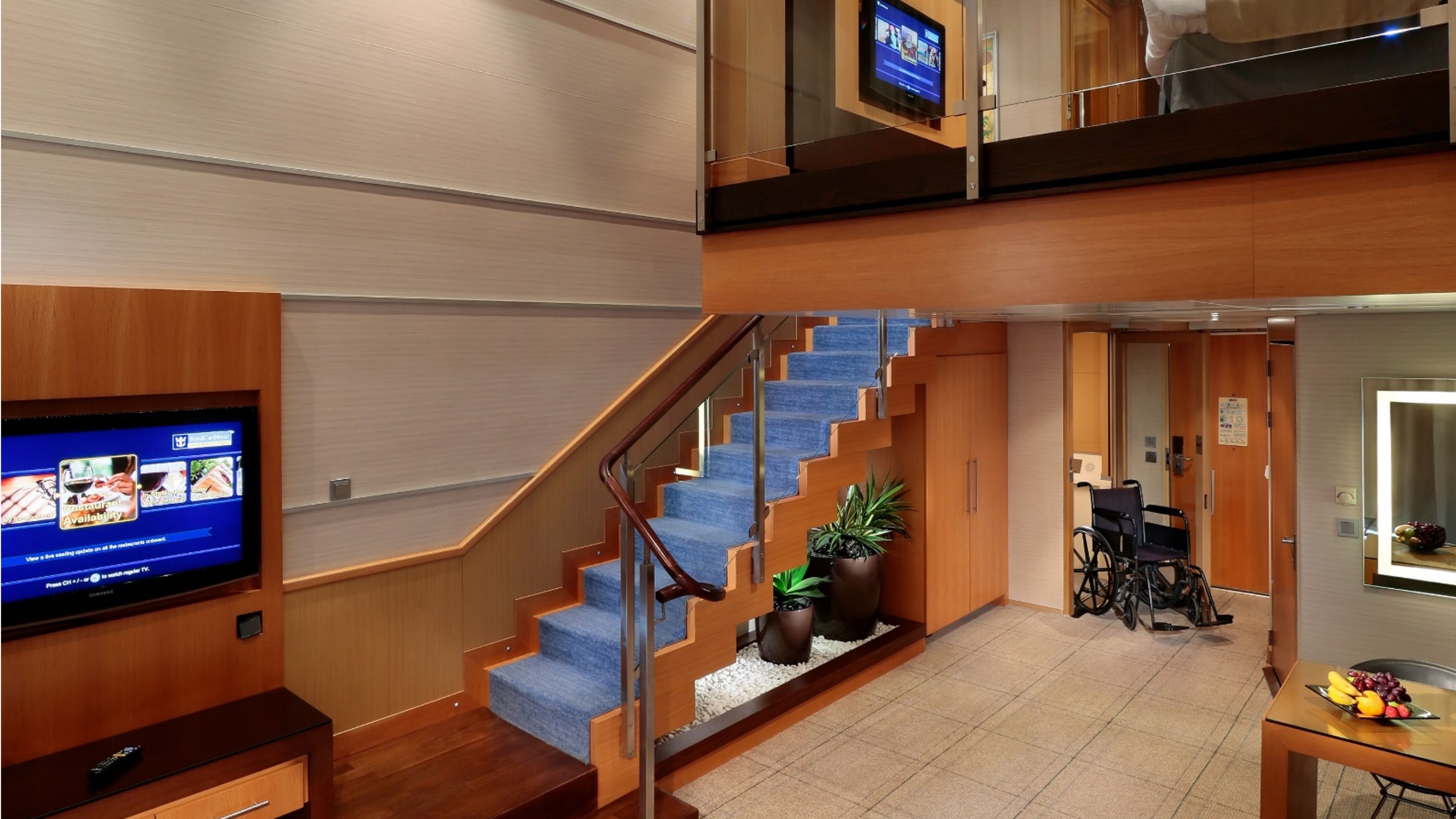 Image shows both stairs and an elevator as options for reaching the upper level of a Royal Caribbean suite
