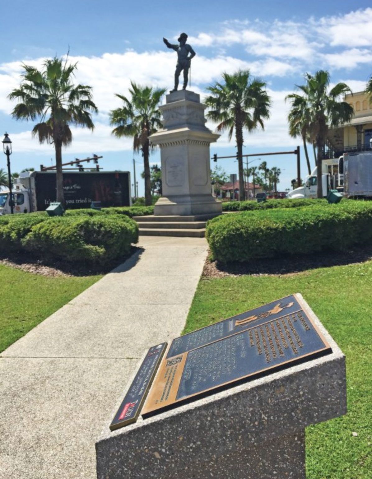 A plaque with Braille text near a statue