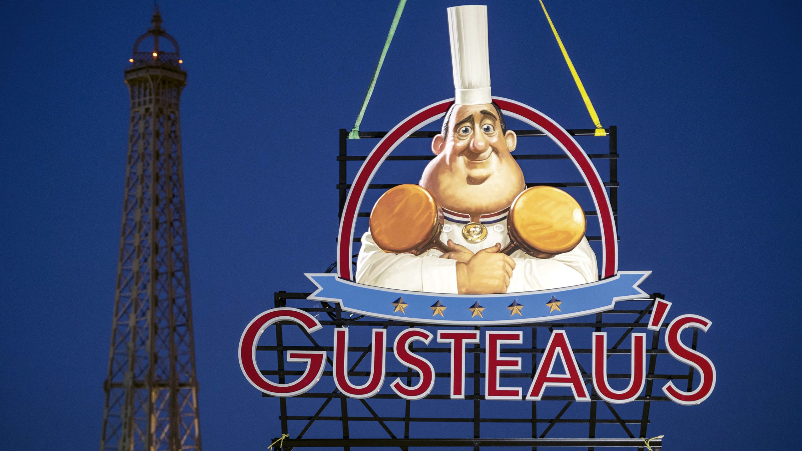 The sign for Gusteau’s restaurant, the setting of Remy’s Ratatouille Adventure, goes up in the France pavilion.